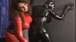 Dominant lesbian in latex red suit strap fucks submissive girl and rides her face